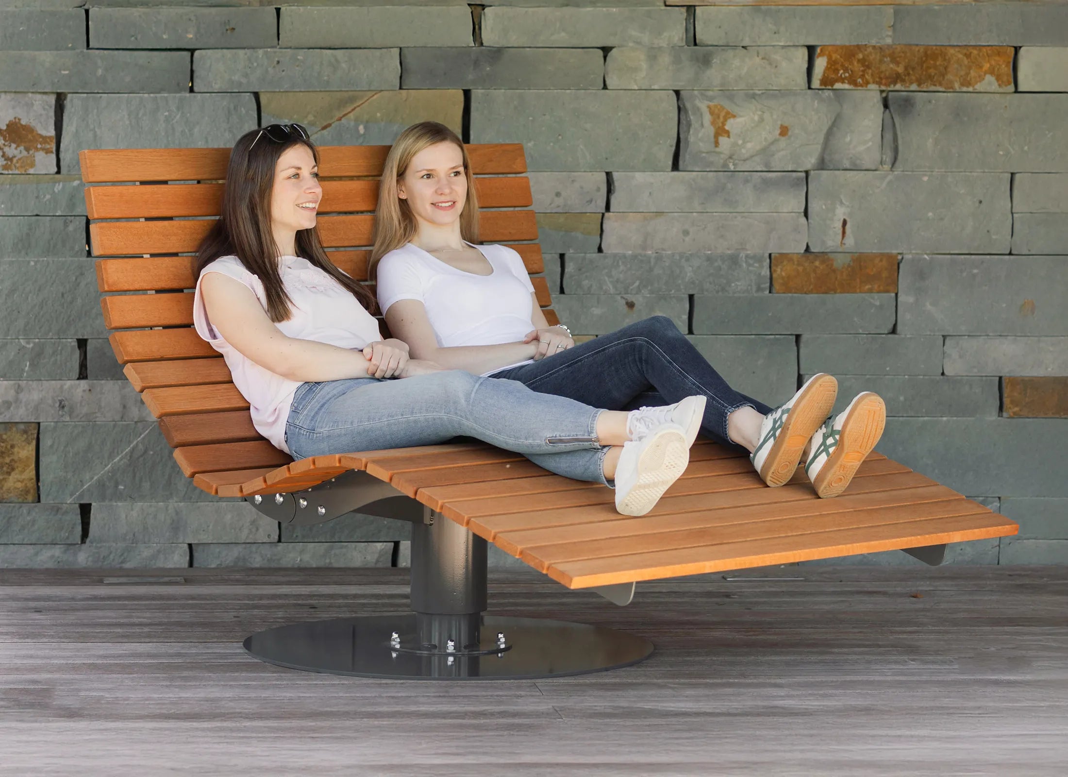 Dreh-Waldliege von Liegeland aus Bangkirai mit Grundplatte, stabile Outdoor-Doppelliege und rotierbare Garten-Relaxliege mit Personen in natürlicher Umgebung.