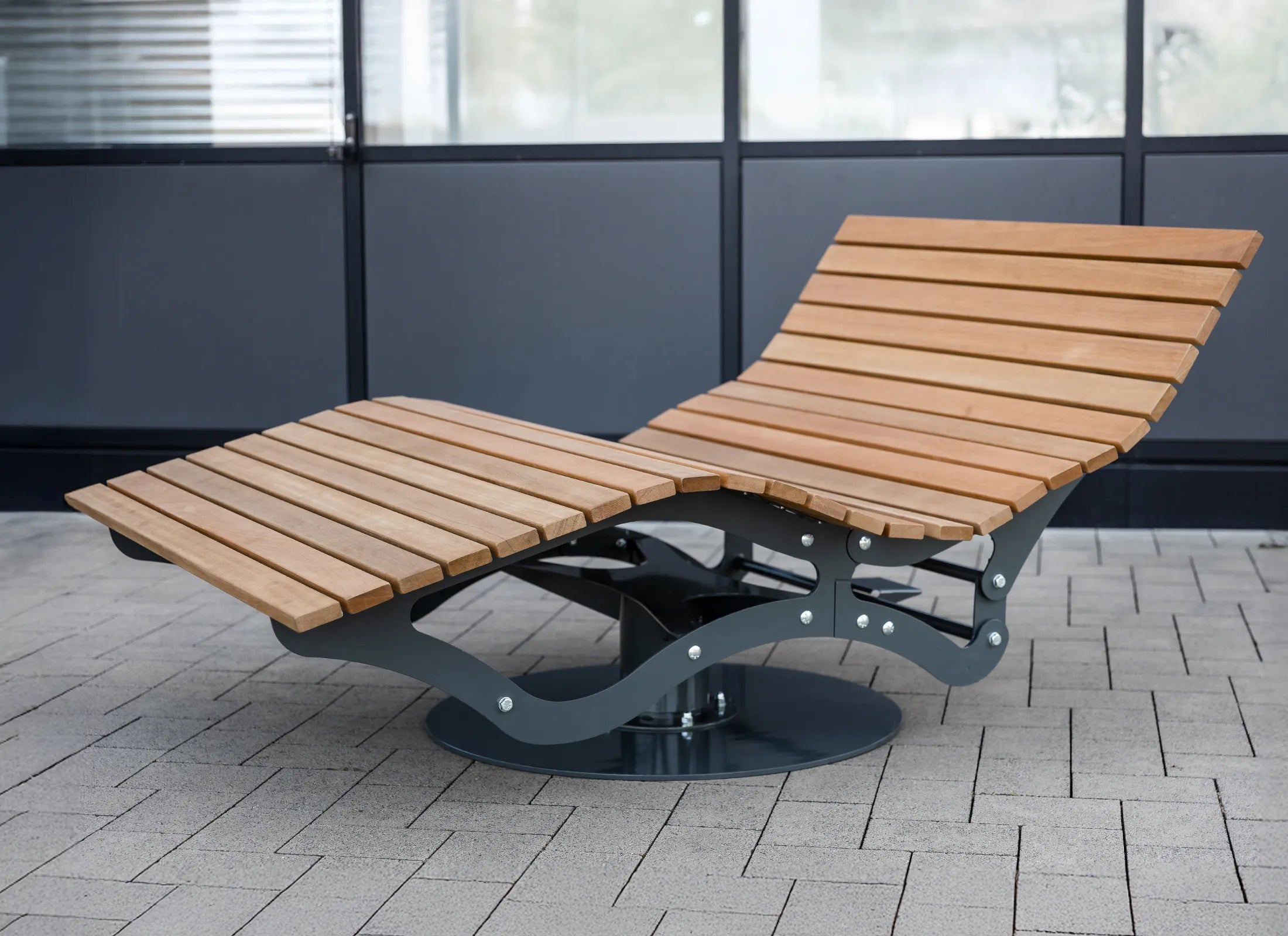 Dreh- und verstellbares Waldsofa von Liegeland auf einem Unicampus, robuste Drehliege und Natur-Liegesofa mit werkzeuglos einstellbarer Rückenlehne und pulverbeschichtetem Stahlgestell. Dargestellt ist die tiefste Position der Rückenlehne. 