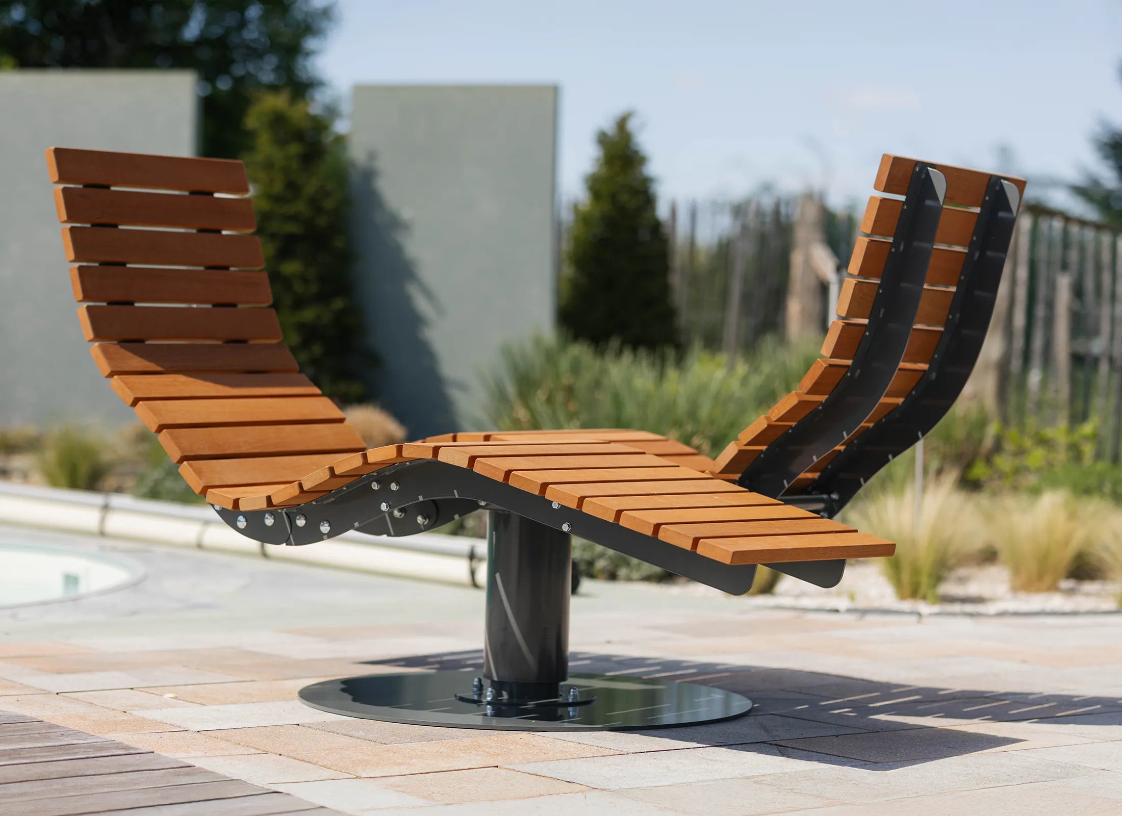 Gegenüberliegendes Waldsofa von Liegeland als 360° Panorama-Liege und moderne Outdoor-Wellenliege, drehbare Wellnessliege in Park- und Gartenanlage.