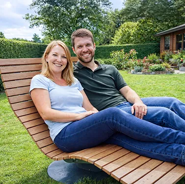 Paar entspannt auf verstellbarem Waldsofa von Liegeland im Garten – ergonomische Waldliege, Wellenliege und Relaxliege mit verstellbarer Rückenlehne, zufriedene Kunden teilen ihre positive Erfahrung